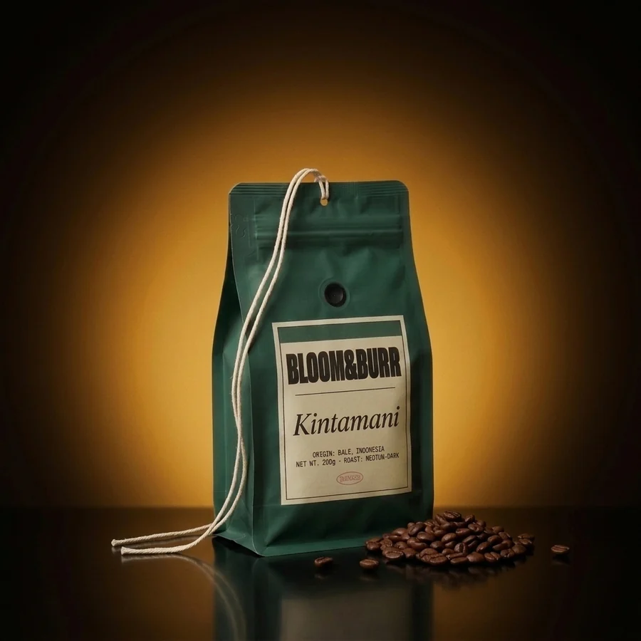 The Kintamani pouch standing on the glossy floor in the same glow, a heap of roasted beans beside it